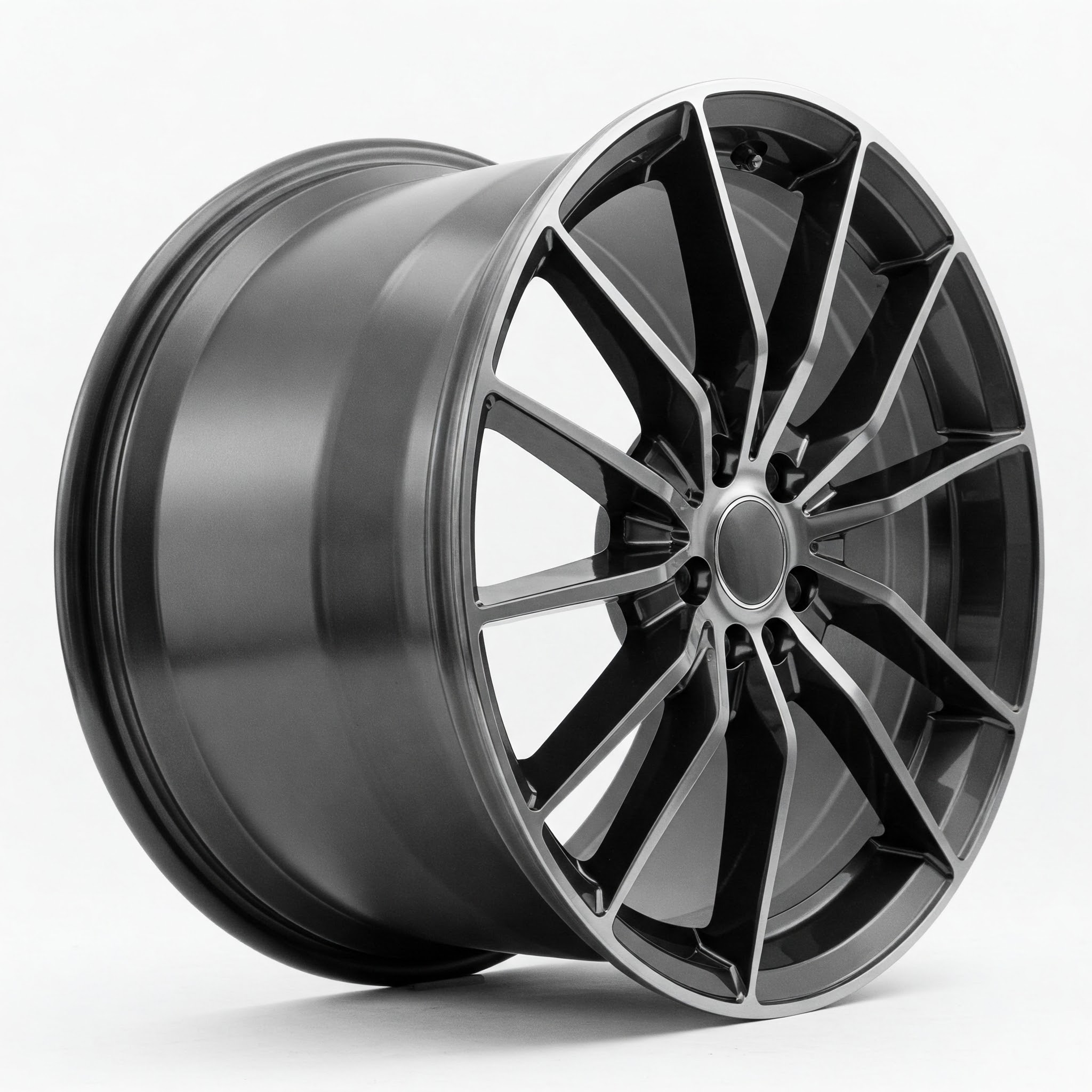 Close-up angled view of a dark grey alloy rim with a multi-spoke design and silver lip, isolated on a white background. The rim is displayed without a tire, showcasing its intricate design and metallic finish.