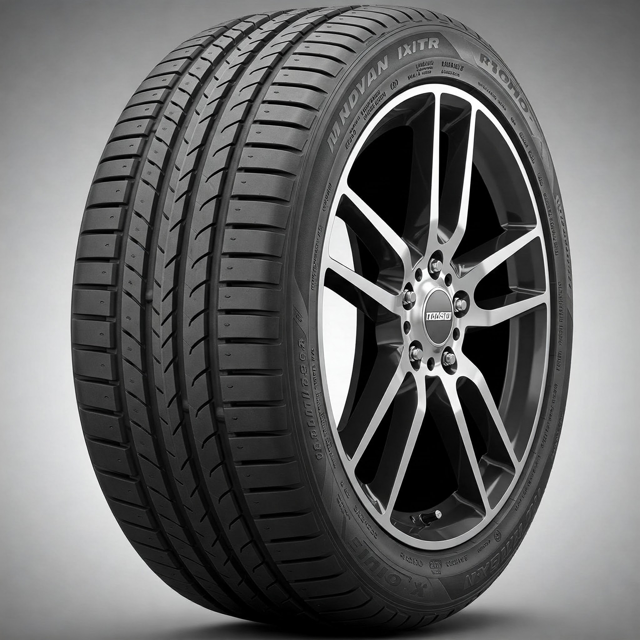 A close-up of a touring tire mounted on a stylish alloy wheel. The tread pattern features straight, evenly spaced grooves designed for a smooth and quiet ride, emphasizing durability and fuel efficiency.