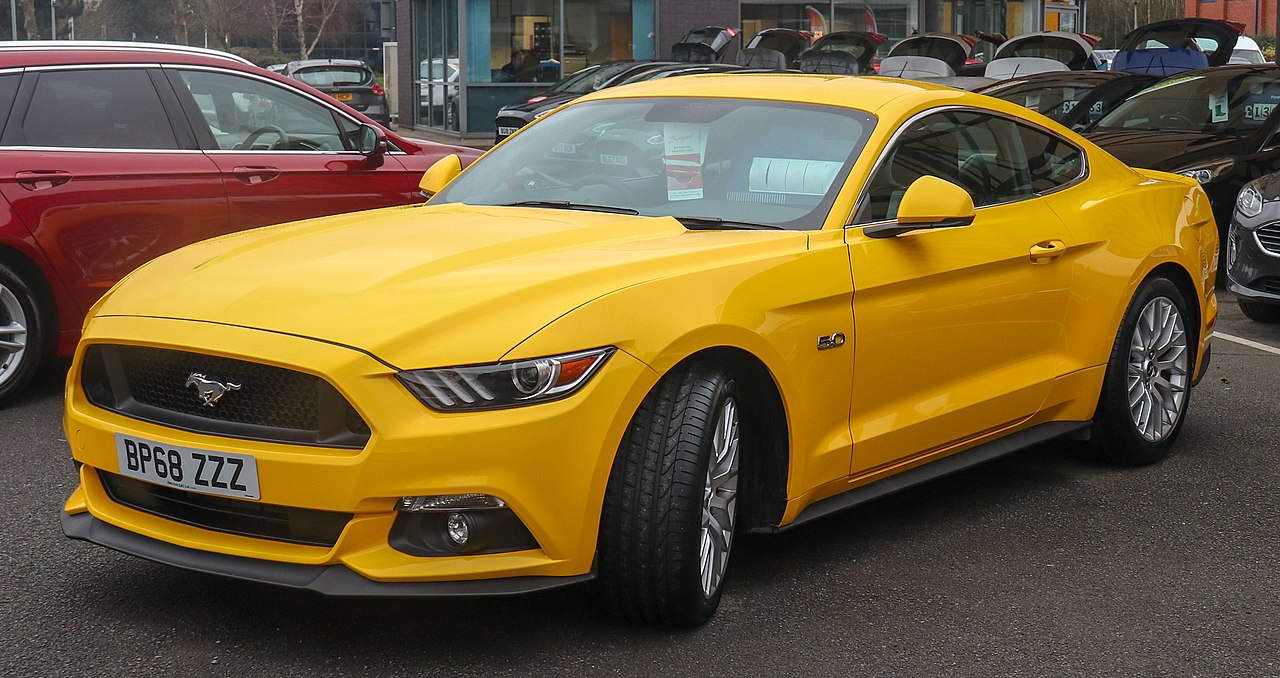 A 2018 Ford Mustang GT 5.0, showcasing its modern and aggressive design. The car features sharp headlights, a large blacked-out grille, and a deep front fascia. The iconic 5.0 badge on the fender hints at the powerful V8 engine under the hood.