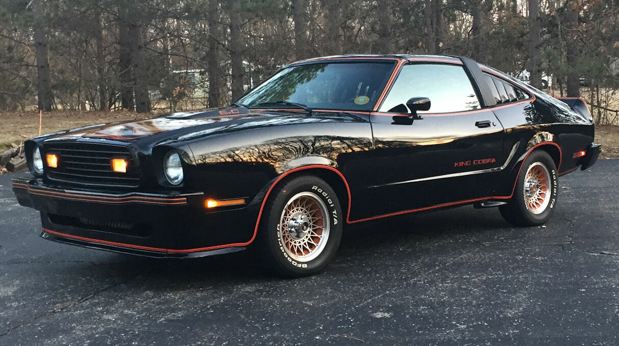 A 1978 Ford Mustang II King Cobra, featuring a sporty and compact body style with a bold cobra hood decal, unique grille design, and black paint. This special edition model embodies the late 1970s Mustang era with its distinct muscle car-inspired styling.