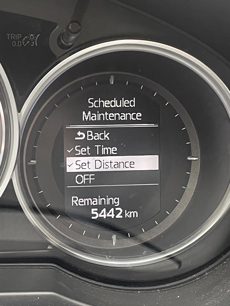 An option in the car's dashboard, which allows you to see when you have to change the car's oil. It says "Scheduled Maintenance" and then "set distance" is chosen. There are 5442 km remaining before the next oil change. 